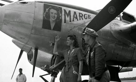 Fighter pilot Richard Ira Bong and his wife, Marge Sieland, pose on an airstrip next to Bong’s P-38 Lightning (also…