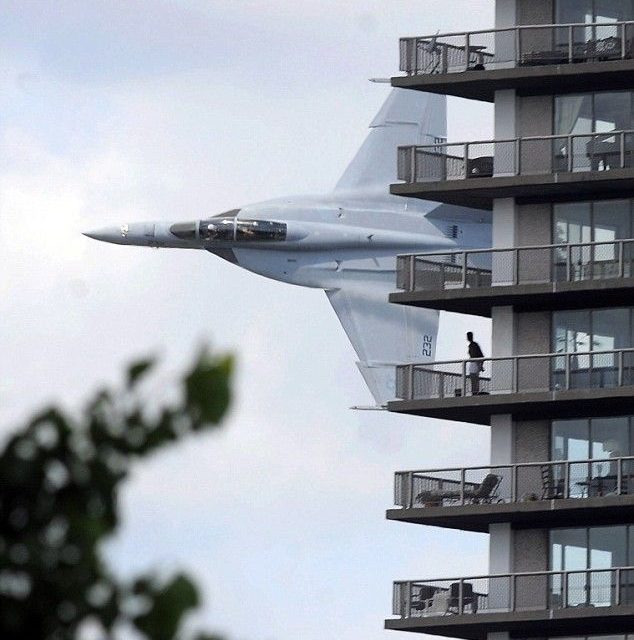 US Navy F18 streaks past apartment block